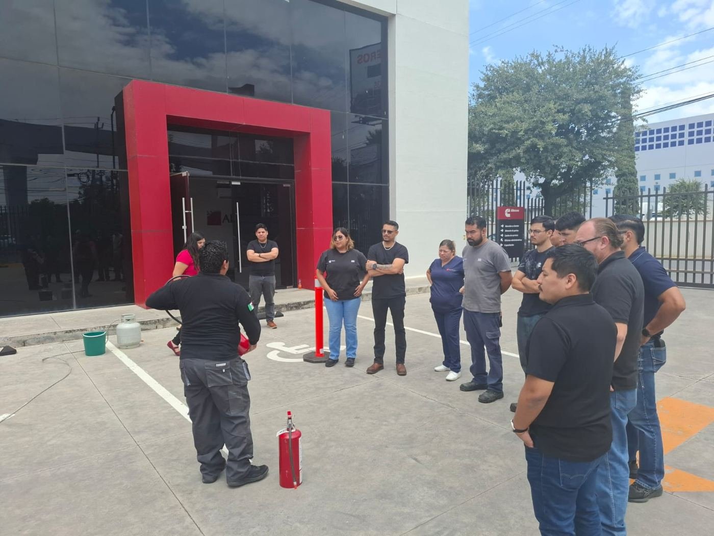 Brigada de empresa reunida frente a extintores en exterior