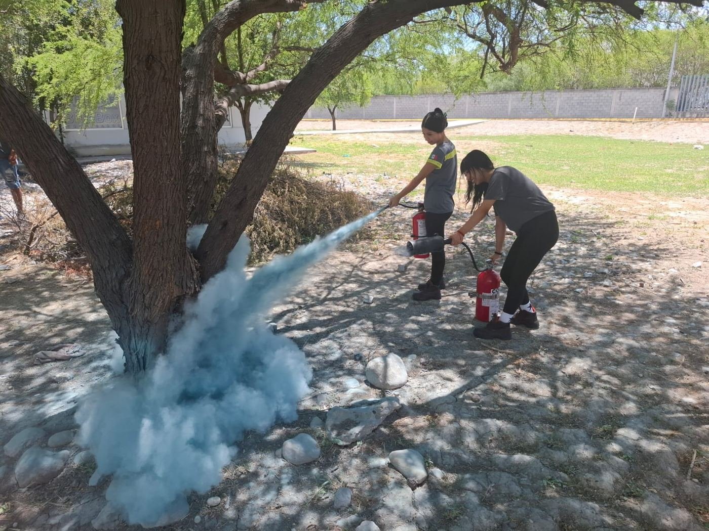 Brigadistas descargando extintores al aire libre